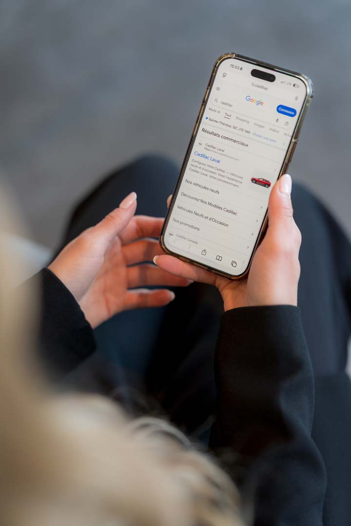Mains tenant un téléphone intelligent affichant des résultats de recherche Google